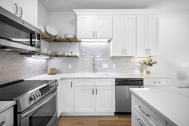 kitchen featuring sink, white cabinetry, appliances with stainless steel finishes, and tasteful backsplash