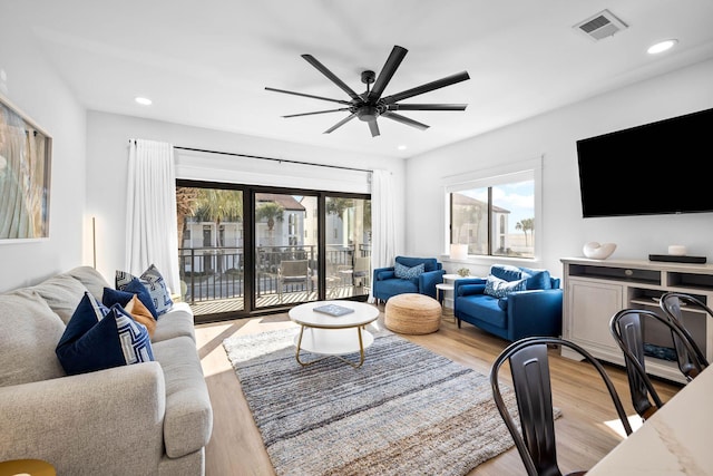 living room featuring light wood-type flooring and ceiling fan