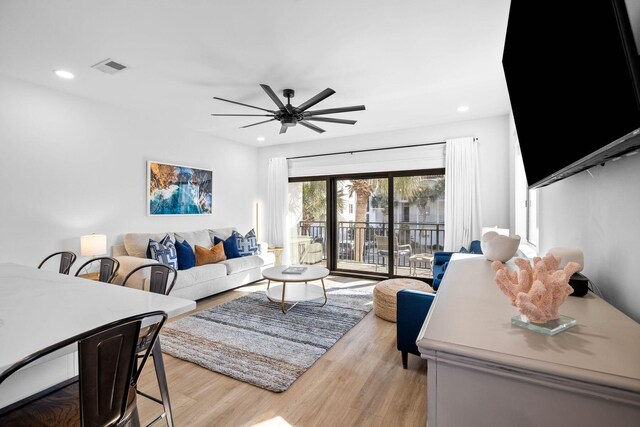 living room featuring ceiling fan and light hardwood / wood-style floors