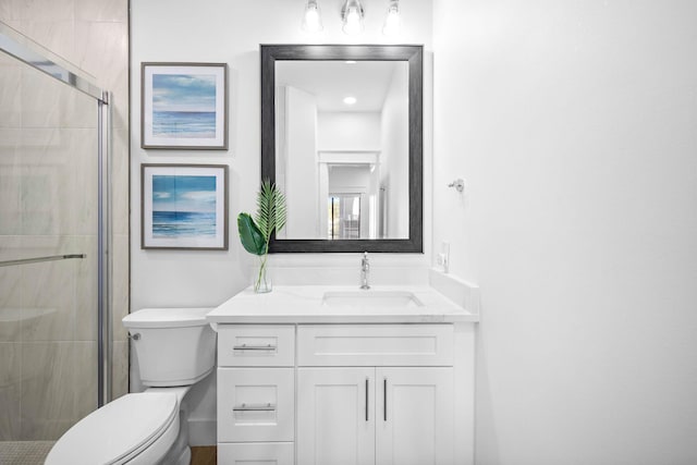 bathroom with toilet, vanity, and an enclosed shower