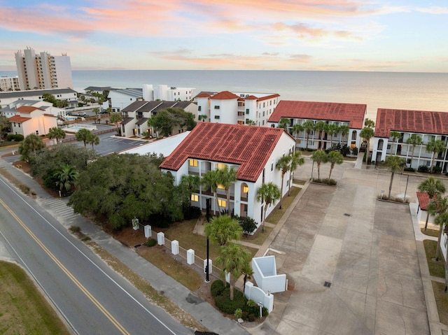 aerial view at dusk featuring a water view