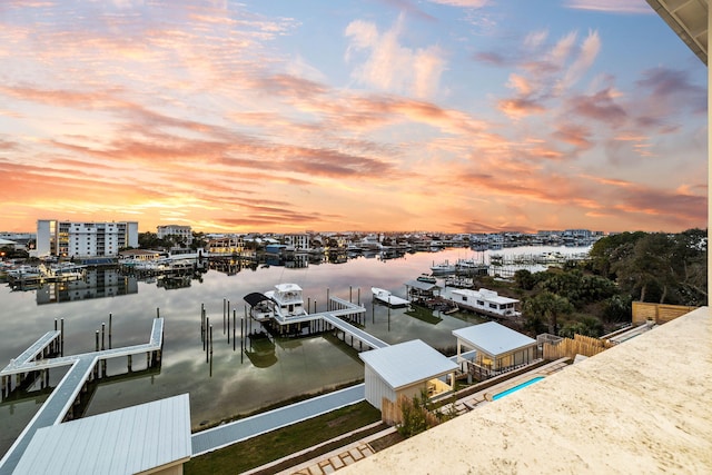 aerial view at dusk featuring a water view