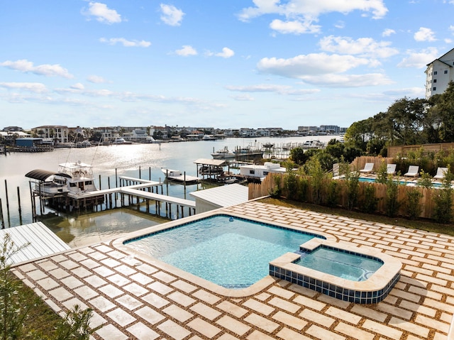 view of pool featuring a patio area, a water view, an in ground hot tub, and a dock