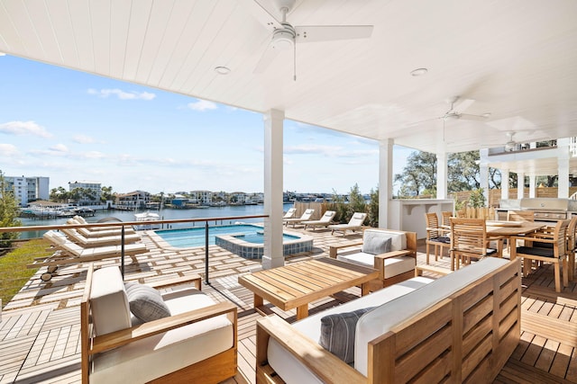 view of patio / terrace with ceiling fan, outdoor lounge area, a swimming pool with hot tub, and a water view