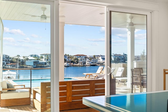 doorway to outside featuring ceiling fan and a water view