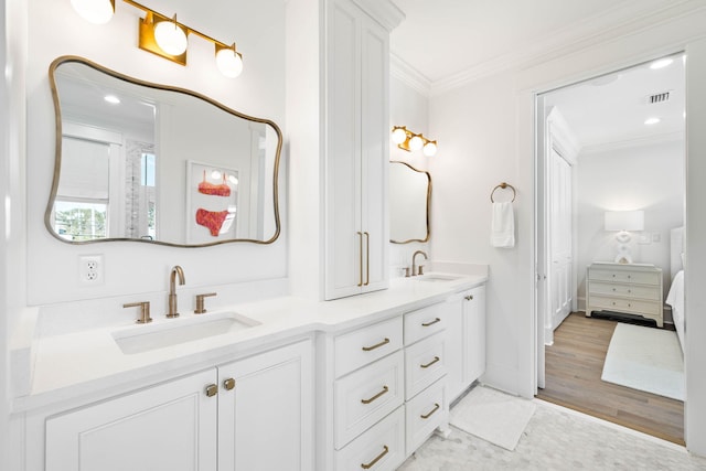 bathroom with vanity, wood-type flooring, and ornamental molding