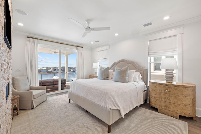 bedroom featuring ceiling fan, access to exterior, ornamental molding, and a water view