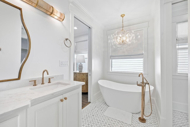 bathroom featuring an inviting chandelier, a bathtub, tile patterned floors, crown molding, and vanity