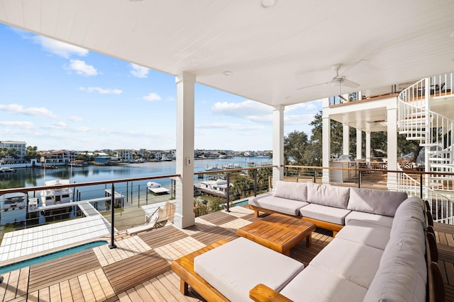 wooden deck featuring a water view, ceiling fan, and outdoor lounge area