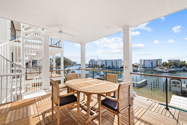 wooden deck with a water view and ceiling fan