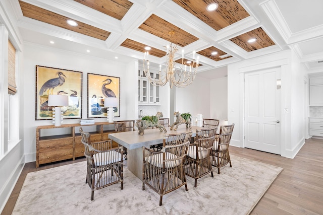 dining area featuring beamed ceiling, light hardwood / wood-style floors, a chandelier, crown molding, and coffered ceiling