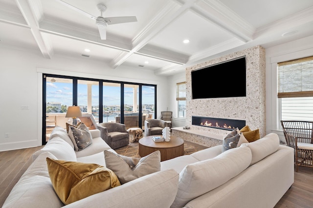 living room with ceiling fan, hardwood / wood-style floors, a large fireplace, beamed ceiling, and coffered ceiling