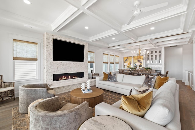 living room featuring coffered ceiling, a large fireplace, dark hardwood / wood-style flooring, ornamental molding, and beamed ceiling