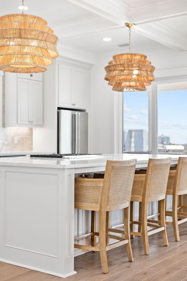 kitchen featuring white cabinets, an inviting chandelier, backsplash, crown molding, and high end fridge