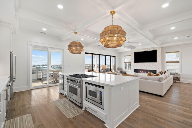 kitchen featuring decorative light fixtures, a fireplace, coffered ceiling, white cabinetry, and stainless steel appliances