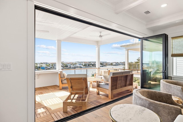 sunroom featuring ceiling fan, beam ceiling, and a water view