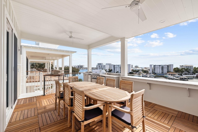 wooden terrace with ceiling fan and area for grilling