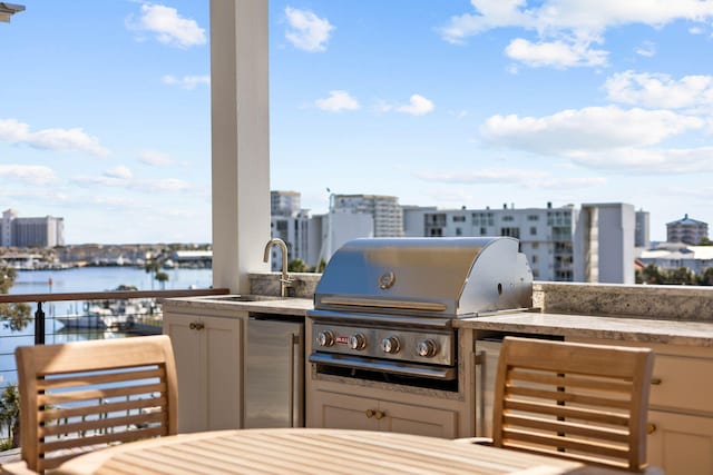 view of patio with grilling area, sink, a water view, and area for grilling