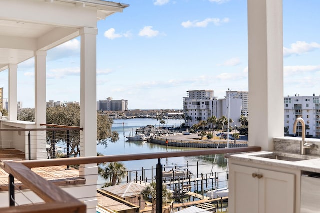 balcony featuring sink and a water view