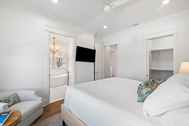 bedroom featuring ceiling fan with notable chandelier, dark wood-type flooring, a closet, ensuite bathroom, and crown molding