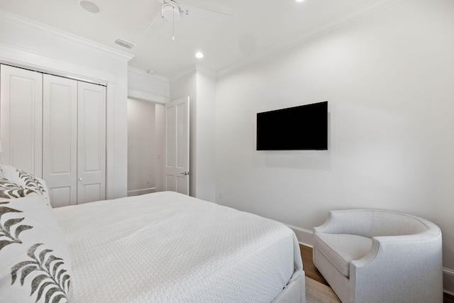 bedroom with ceiling fan, a closet, ornamental molding, and wood-type flooring