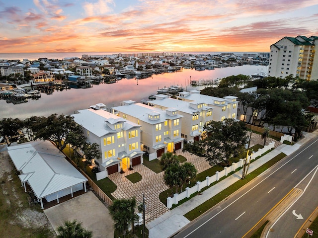 aerial view at dusk featuring a water view