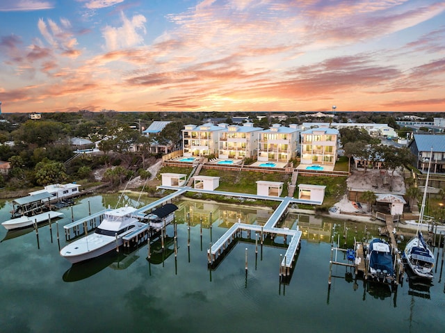 aerial view at dusk featuring a water view