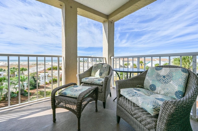 balcony featuring a beach view and a water view