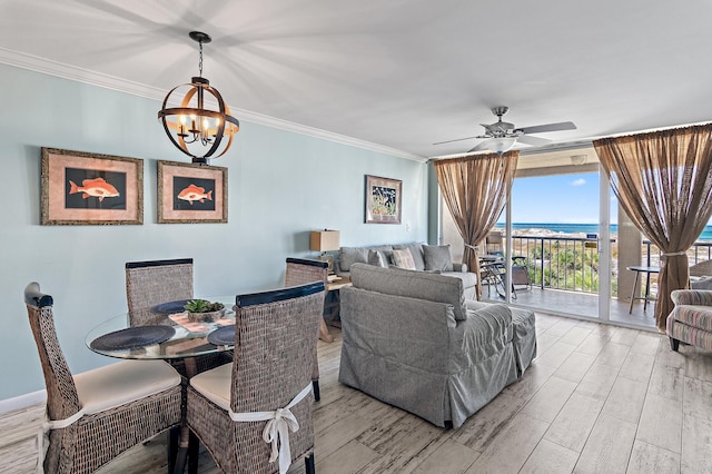 living room featuring crown molding, a wall of windows, a water view, and ceiling fan with notable chandelier