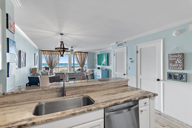 kitchen with stainless steel dishwasher, sink, an inviting chandelier, white cabinetry, and ornamental molding