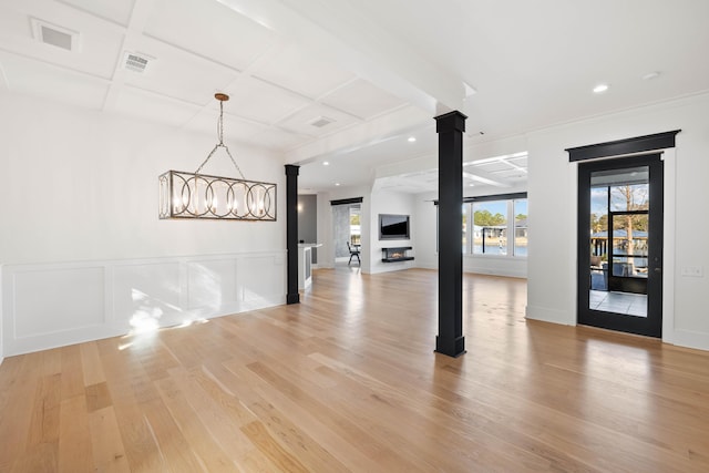 unfurnished room featuring light wood-style flooring, coffered ceiling, visible vents, wainscoting, and ornate columns