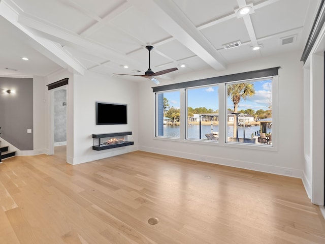 unfurnished living room featuring coffered ceiling, visible vents, baseboards, light wood-type flooring, and a glass covered fireplace