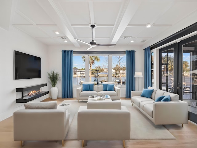 living area with a warm lit fireplace, coffered ceiling, beamed ceiling, light wood-type flooring, and recessed lighting