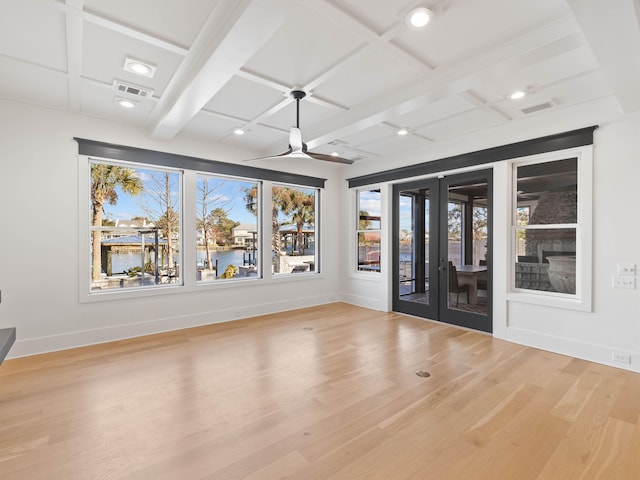 spare room with baseboards, coffered ceiling, light wood-style flooring, a water view, and beam ceiling