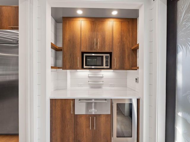 kitchen featuring brown cabinets, open shelves, light countertops, built in appliances, and beverage cooler