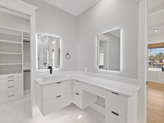 full bathroom featuring ornamental molding, marble finish floor, a spacious closet, and vanity