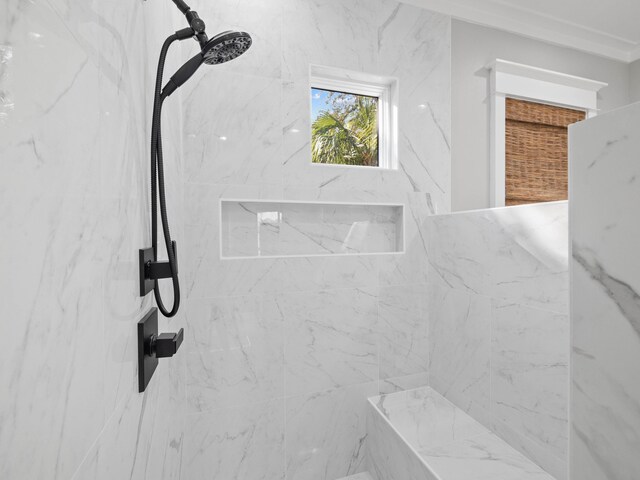 interior details featuring a marble finish shower