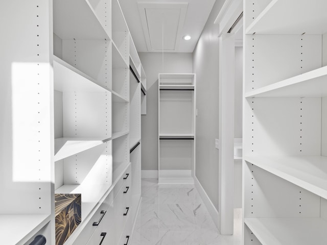 walk in closet featuring attic access and marble finish floor