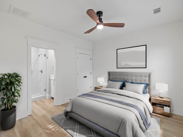 bedroom featuring ornamental molding, light wood-type flooring, visible vents, and baseboards