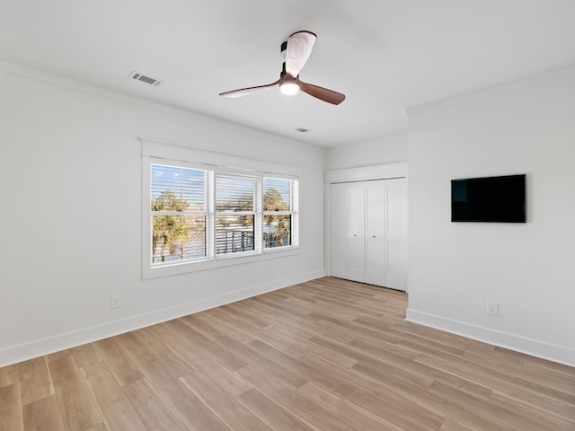 unfurnished bedroom featuring a closet, light wood-type flooring, visible vents, and baseboards