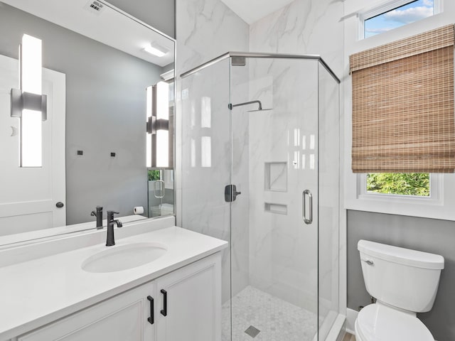 full bathroom featuring vanity, a marble finish shower, toilet, and a healthy amount of sunlight