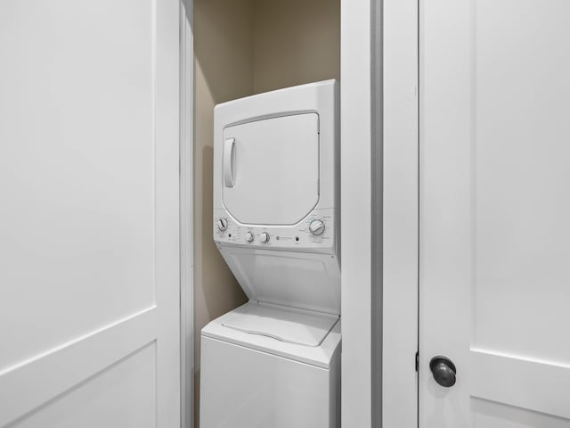 laundry room featuring stacked washer / dryer and laundry area