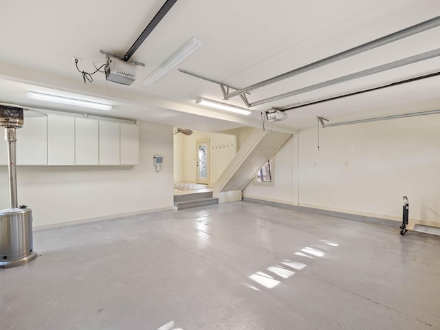 garage featuring a garage door opener and baseboards