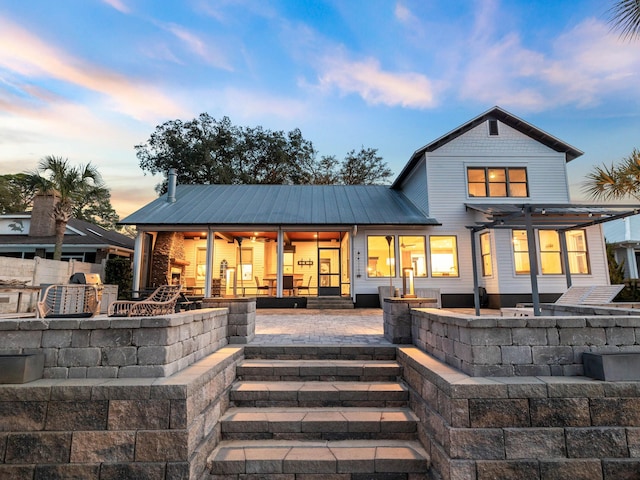 back of property at dusk with a patio area