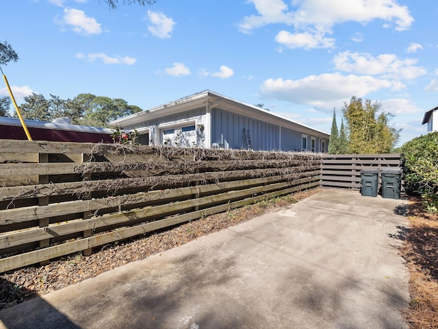 exterior space with board and batten siding and fence