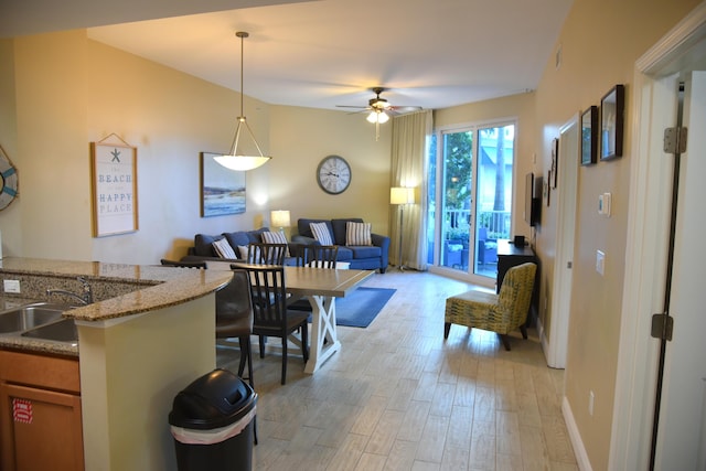 dining space featuring ceiling fan and sink