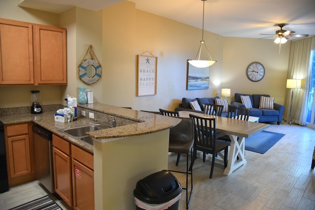 kitchen featuring sink, hanging light fixtures, stainless steel dishwasher, kitchen peninsula, and light wood-type flooring