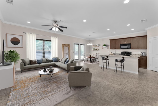 living room with ceiling fan with notable chandelier, sink, and ornamental molding