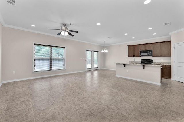 kitchen featuring a kitchen bar, light stone countertops, ornamental molding, ceiling fan with notable chandelier, and black appliances