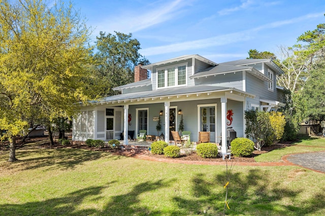 view of front of home with covered porch, a front yard, and a garage